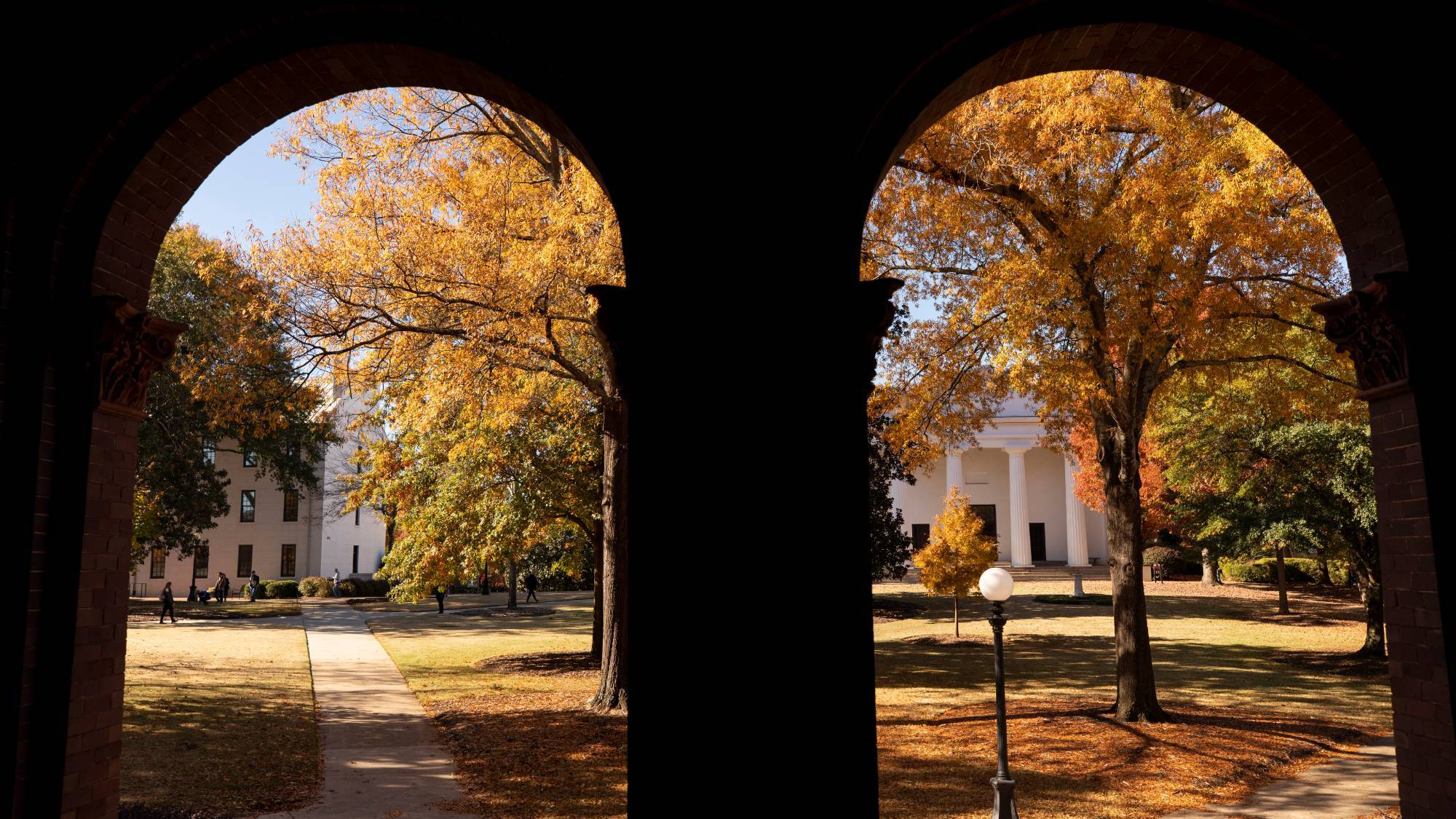 View through two brick archways to a campus quad in autumn
