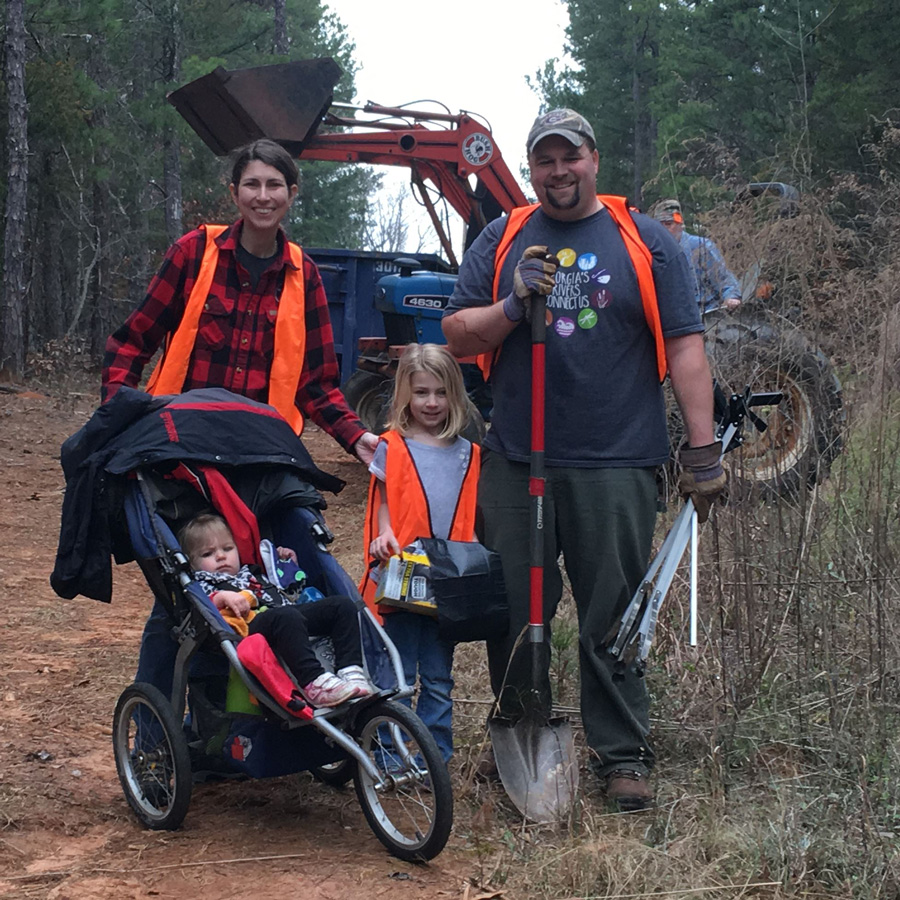 Photo of Andrew Saunders and his family outside at a volunteer cleanup event