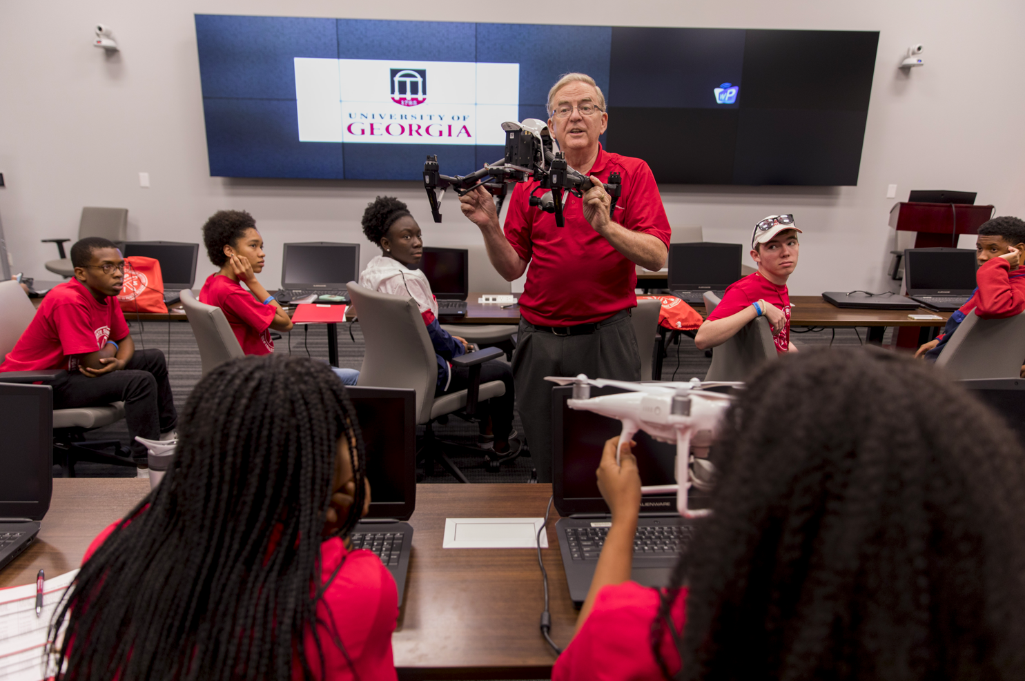 genai A man showing a drone to a class of students