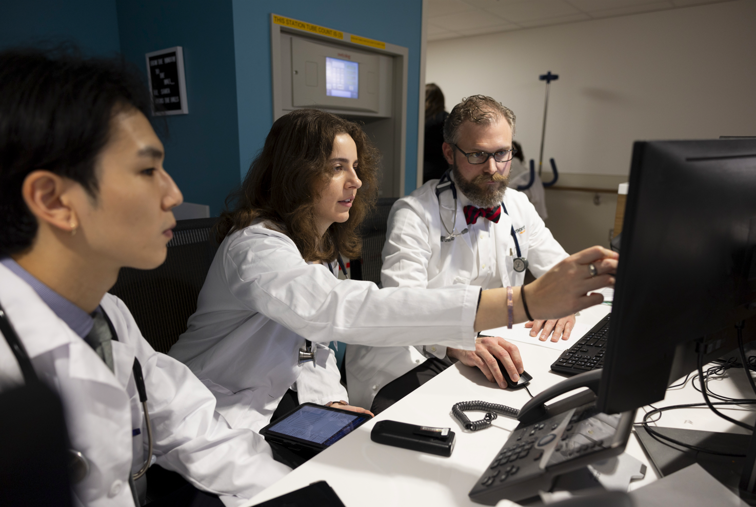 Three people looking at a computer in a lab setting